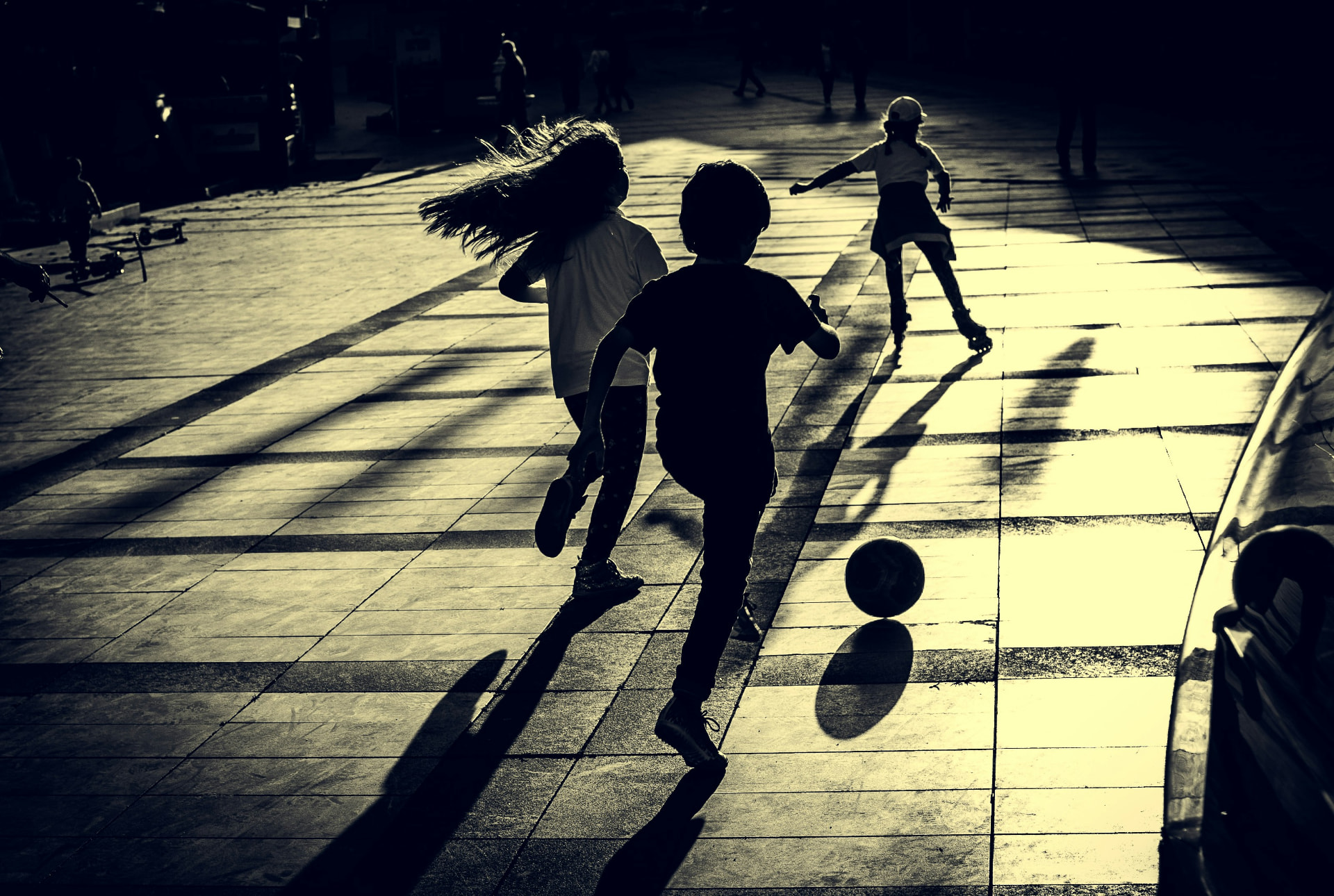 Kids playing freely at sunset, silhouetted against the light